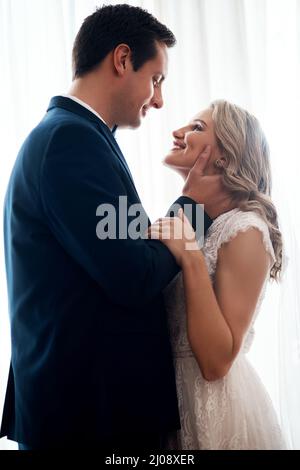 Vous êtes l'être le plus angélique que j'aie jamais vu. Photo courte d'un jeune couple heureux debout à l'intérieur et se tenant ensemble affectueusement après leur Banque D'Images