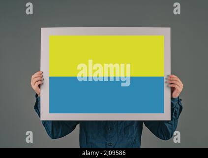 Le jeune homme porte un signe avec le drapeau ukrainain, l'idendité nationale, la crise de guerre entre l'Ukraine et la Russie, la question politique, bleu et jaune de couleur Banque D'Images