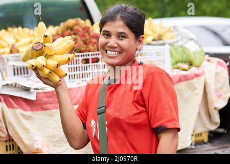 Je vends uniquement les produits les plus frais. Portrait d'une femme qui vend des bananes à son marché stalle à l'extérieur. Banque D'Images