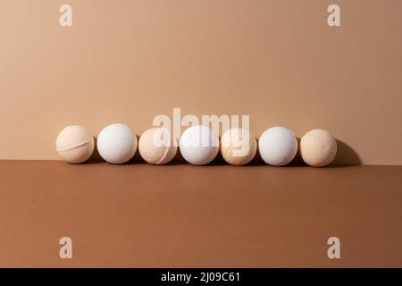 Les bombes de bain bio avec ombre sur fond beige. Concept spa. Cadeaux pour le corps. Espace pour le texte. Banque D'Images