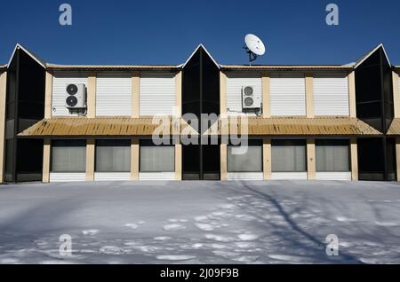 bâtiment non résidentiel abandonné avec parabole satellite sur le toit en hiver, photographie de la zone morte Banque D'Images