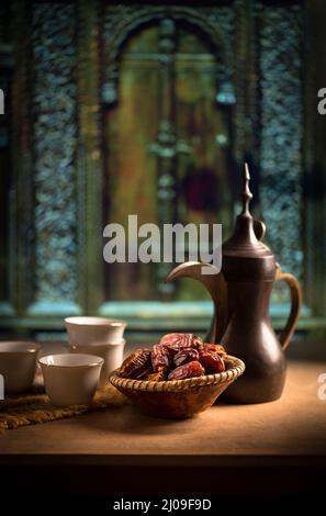 Belle vie encore d'une ancienne cafetière arabe et dates. Cuisine et boissons traditionnelles du Moyen-Orient dans un cadre rustique. Banque D'Images