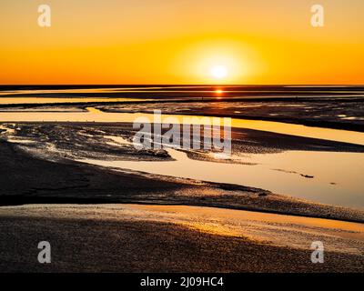 Le Mont Saint Michel, magnifique coucher de soleil sur les appartements de sable entourant la célèbre abbaye à marée basse, Normandie, Nord de la France Banque D'Images