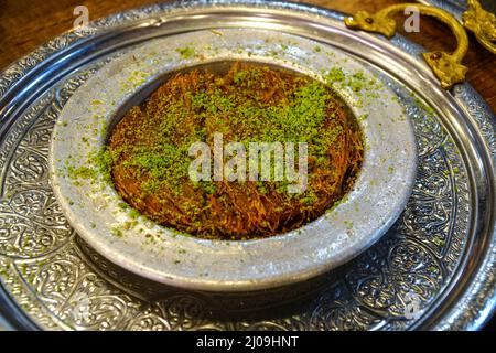 Dessert Kunefe, vue de dessus du traditionnel dessert turc kunefe avec pistaches sur le dessus. Banque D'Images