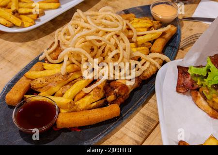 Croquettes de thon, tapas, canapés, hors-d'œuvre et en-cas frits et battus, pommes de terre bouillies et pelées, bâtonnets de poisson, oignons frits, ailes de poulet et sa Banque D'Images