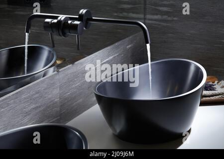 Table de mixage noire dans la salle de bains moderne. Évier noir. Robinet d'eau en matériau sombre, Banque D'Images