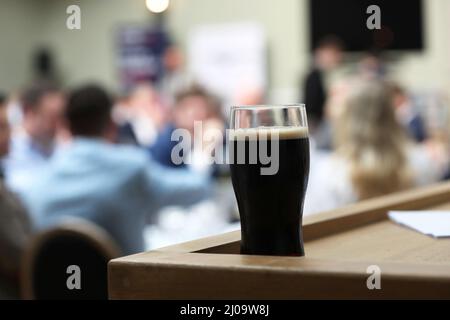 Vue générale sur une pinte de Guinness et des canettes de Guinness dans un hôtel à Sussex, Royaume-Uni. Banque D'Images