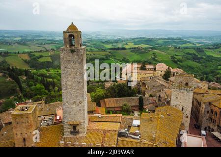 Tour et maisons à toit rouge dans le centre historique de San Gimignano, site classé au patrimoine mondial de l'UNESCO, province de Sienne, région de Toscane, Italie Banque D'Images