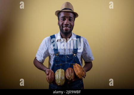 Portrait d'un fermier africain souriant avec des fèves de cacao, producteur africain de cacao Banque D'Images