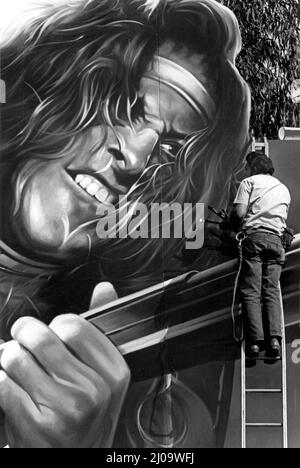 Un peintre de panneaux publicitaires retouchant le visage de Ted Nugent sur un panneau géant de Sunset Strip faisant la promotion de la sortie d'un nouvel album vers 1979, Los Angeles, CA Banque D'Images