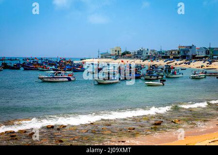 Un petit village de pêcheurs avec une flotte de bateaux amarrés ou ancrés dans une petite crique près de Quy Nhon. Banque D'Images