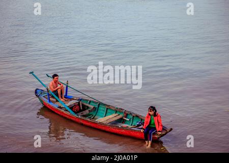 Juste à côté des rives du Mékong, deux personnes s'assoient dans leur bateau à bois de Chau Doc Banque D'Images