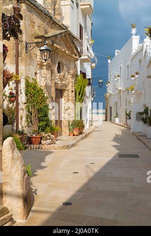 Monopoli - l'allée de la vieille ville avec la petite chapelle. Banque D'Images