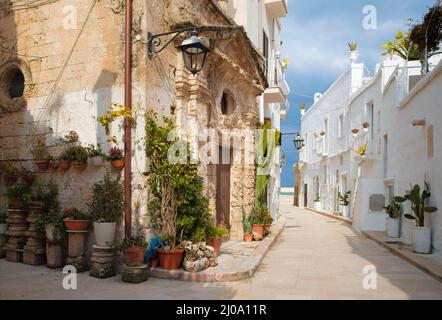 Monopoli - l'allée de la vieille ville avec la petite chapelle. Banque D'Images