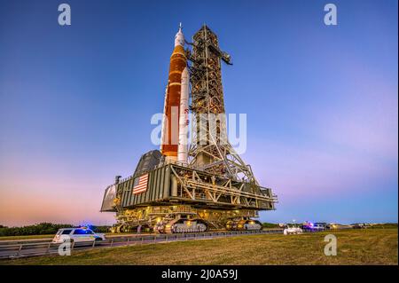 La nouvelle fusée Moon de la NASA au Centre spatial Kennedy, qui fait son premier voyage jusqu'au plateau de lancement. Composée de la fusée SLS (Space Launch System) de la NASA et de l'engin spatial Orion, la fusée Artemis I est prête à rouler le 17 mars pour lancer le complexe 39B pour sa répétition en robe humide le 17 mars 2022 au Kennedy Space Center de Merritt Island, FL pour un lancement prévu pour avril 1. La répétition de l'habillage va tester la capacité de charger près de 700 000 gallons de gaz propulseurs cryogéniques dans la fusée sur le plateau de lancement, de pratiquer le compte à rebours du lancement et de tester la capacité de vidanger les gaz propulseurs pour montrer qu'ils sont debout Banque D'Images