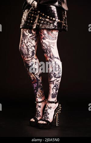 Je possède mon style de la tête aux pieds. Photo de studio d'une femme tatouée jambes. Banque D'Images