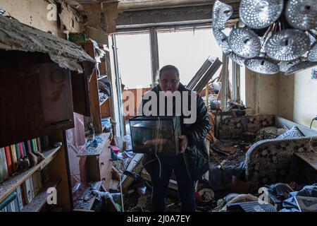 Kiev, Ukraine. 17th mars 2022. Une femme a vu récupérer ses trucs de son appartement endommagé. Alors que la Russie intensifie les bombardements offensifs et les frappes aériennes tout en encerclant la capitale ukrainienne, un bâtiment résidentiel a été frappé par des bombardements mercredi matin, le 16 mars 2022, tuant au moins un civil et en blessant des dizaines de personnes. Crédit : SOPA Images Limited/Alamy Live News Banque D'Images