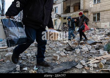 Kiev, Ukraine. 17th mars 2022. Les résidents sont vus récupérer leurs affaires des appartements endommagés. Alors que la Russie intensifie les bombardements offensifs et les frappes aériennes tout en encerclant la capitale ukrainienne, un bâtiment résidentiel a été frappé par des bombardements mercredi matin, le 16 mars 2022, tuant au moins un civil et en blessant des dizaines de personnes. Crédit : SOPA Images Limited/Alamy Live News Banque D'Images