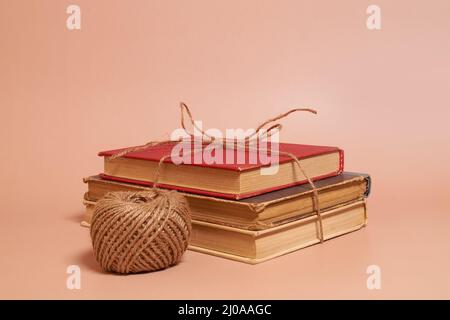 Une pile de vieux livres battus attaché avec la corde de jute, une bobine de corde de jute Banque D'Images