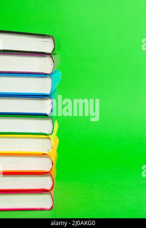 Pile de épines de livres sur fond vert Banque D'Images