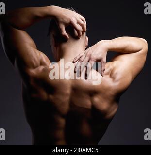 Faites le travail, le muscle suivra. Photo d'un jeune homme musclé posant sur un fond noir. Banque D'Images