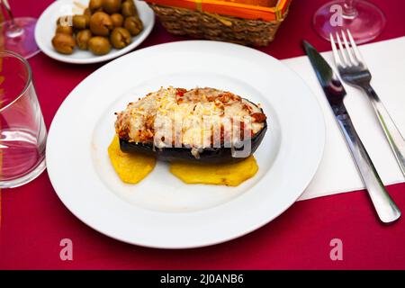 Aubergine farcie grillée avec des tranches de pommes de terre cuites au four Banque D'Images