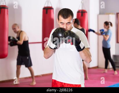 sportif sérieux dans la salle de boxe pratiquant des coups de boxe Banque D'Images