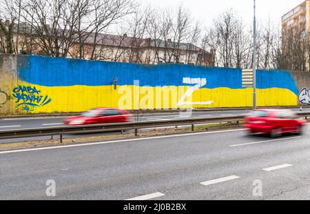 Teplice, République tchèque. 17th mars 2022. Les médecins légistes ont cherché des traces autour de la lettre majuscule blanche Z, qui est apparue sur le mur bordant le tronçon à travers la ville de Teplice, République tchèque, peinte dans les couleurs du drapeau ukrainien, le 17 mars 2022. En Russie, les gens placent la lettre Z sur des voitures, des maisons ou des vêtements, par exemple. Ils expriment leur soutien aux forces russes en Ukraine. Crédit : Ondrej Hajek/CTK photo/Alay Live News Banque D'Images