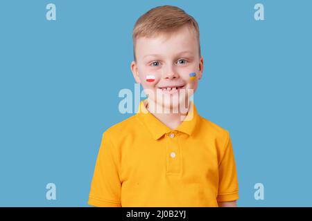 Portrait d'un garçon mignon avec drapeaux tirés sur ses joues de l'Ukraine et de la Pologne. Concept d'amitié des peuples Banque D'Images