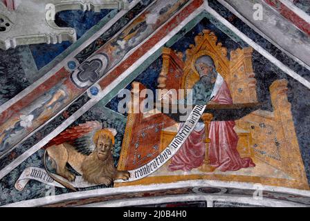 Saint Mark l'évangéliste, accompagné de son symbole de lion ailé, est assis à un bureau écrivant son Evangile en 1400s piémontais cycle de fresque gothique tardif. Sur la voûte au plafond dans l'église de l'ancien couvent franciscain à Susa, Piémont, Italie. Banque D'Images