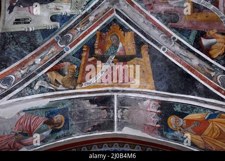 Saint Mark l'évangéliste, accompagné de son symbole de lion ailé, est assis à un bureau écrivant son Evangile en 1400s piémontais cycle de fresque gothique tardif. Sur la voûte au plafond dans l'église de l'ancien couvent franciscain à Susa, Piémont, Italie. Au-dessous de Saint Marc, sous les canopies gothiques, se trouvent Saint Paul (à gauche) et Saint Pierre (à droite). Banque D'Images