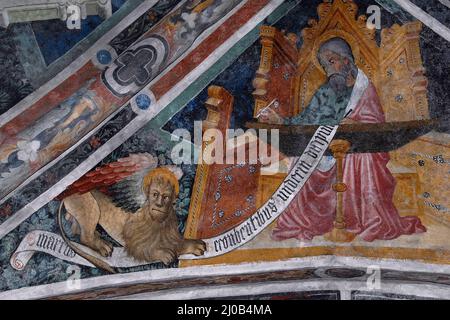 Saint Mark l'évangéliste, accompagné de son symbole de lion ailé, est assis à un bureau écrivant son Evangile en 1400s piémontais cycle de fresque gothique tardif. Sur la voûte au plafond dans l'église de l'ancien couvent franciscain à Susa, Piémont, Italie. Banque D'Images