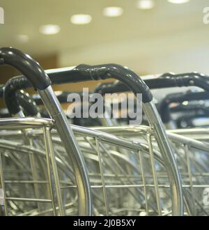 Des chariots à bagages sont en rangées dans le salon des arrivées de l'aéroport Banque D'Images