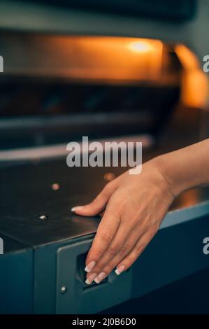 Jeune femme travaillant dans une usine d'impression. Outils d'impression Banque D'Images