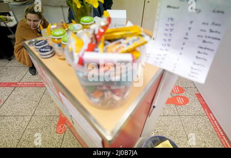 Hambourg, Allemagne. 18th mars 2022. Valeriia, 26 ans, une réfugiée de Kiev, capitale ukrainienne, parle sur son smartphone dans une salle de l'Arbeiter-Samariter-Bund (ASB) après son arrivée à la gare centrale. Le personnel et les volontaires de l'ASB, ainsi que les traducteurs, accueillent les réfugiés ukrainiens à leur arrivée à la gare centrale de Hambourg. Les réfugiés sont aidés avec des boissons et de la nourriture ainsi que des informations sur l'enregistrement, l'hébergement gratuit ou les voyages. Credit: Marcus Brandt/dpa/Alay Live News Banque D'Images