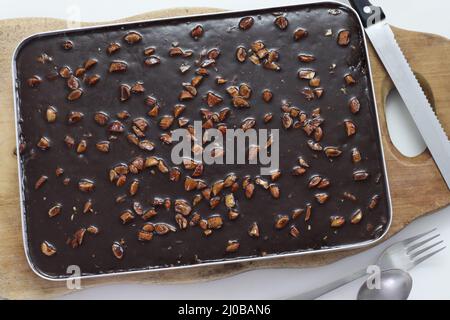 Gâteau Texas. Beurre et gâteau au chocolat à l'intérieur de la corbeille de cuisson. Frais du four. Prise de vue sur fond blanc Banque D'Images