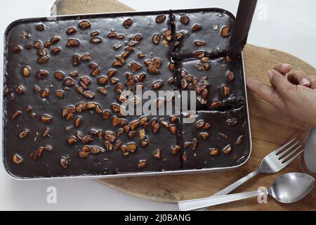 Tranche de gâteau de feuille de Texas. Beurre et gâteau au chocolat coupés en morceaux rectangulaires à l'intérieur de la corbeille à pain. Frais du four. Prise de vue sur fond blanc Banque D'Images