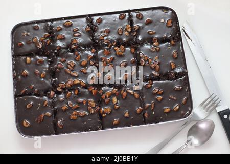 Tranche de gâteau de feuille de Texas. Beurre et gâteau au chocolat coupés en morceaux rectangulaires à l'intérieur de la corbeille à pain. Frais du four. Prise de vue sur fond blanc Banque D'Images