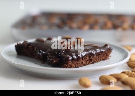 Tranche de gâteau de feuille de Texas servi sur une assiette. Beurre et gâteau au chocolat coupés en morceaux rectangulaires à l'intérieur de la corbeille à pain et coupés en morceaux. Photo o Banque D'Images