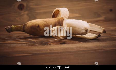 Fruits frais de banane biologique sur une table en bois. Gros plan Banque D'Images