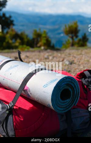 Sac à dos rouge gros plan avec matelas fixe sur le sol pierreux en face de mountain et Tajumulco ciel bleu avec des nuages Banque D'Images