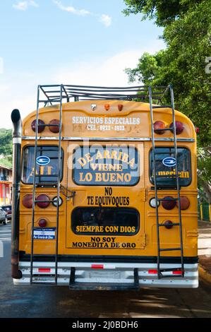 Arrière d'un autobus scolaire jaune garée dans la rue avec des lettres sur elle Banque D'Images