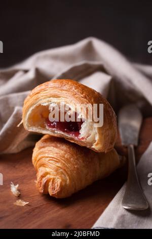 Gros plan du croissant avec de la confiture sur un fond de bois. selective focus Banque D'Images
