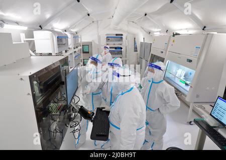 Yantai, Chine. 18th mars 2022. Dans la soirée du 17 mars 2022, le personnel a installé et débogué du matériel dans le laboratoire ''Huoyan'' à Yantai, Shandong.le 18 mars 2022, après la construction d'une nuit, le laboratoire d'analyse des acides nucléiques ''Huoyan'', d'une capacité quotidienne de 60 000 tubes individuels, a été achevé à Yantai Gymnasium, dans la province de Shandong. À l'heure actuelle, le personnel intensifie l'installation et la mise en service de l'équipement, qui peut répondre à jusqu'à 600 000 besoins de tests d'acides nucléiques par jour après sa mise en service. Crédit : ZUMA Press, Inc./Alay Live News Banque D'Images