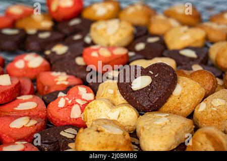 Gros plan d'un groupe de biscuits de coeur assortis. Chocolat , fromage et fraise , flocons d'avoine , chocolat blanc remplir le cadre. Petits gâteaux faits maison sur la table. Banque D'Images
