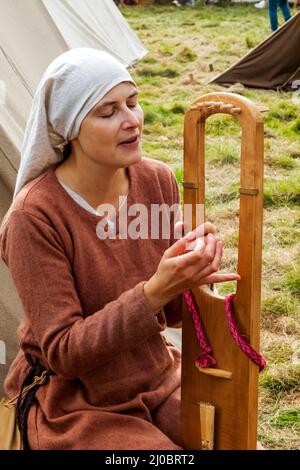 Angleterre, East Sussex, Battle, The Annual Battle of Hastings 1066 Re-promulgation Festival, Femme participant vêtue de costume médiéval jouant Medieva Banque D'Images