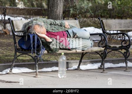 Sans-abri dormant sur un banc Banque D'Images