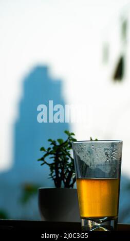 Une photo d'un thé au citron vert dans un grand verre conservé près d'une fenêtre ouverte. Le thé au citron vert est une boisson saine à boire le soir Banque D'Images
