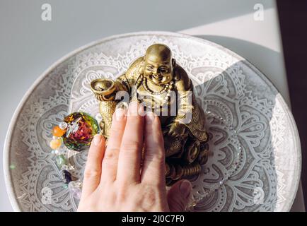 Personne frottant la main petit doré riant Bouddha figurine tummy. Il croyait apporter le bonheur, la bonne fortune et la richesse. Bouddai moine. Banque D'Images