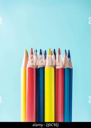 Business concept - crayon de couleur sur fond de papier bleu. C'est le symbole du travail d'équipe Banque D'Images